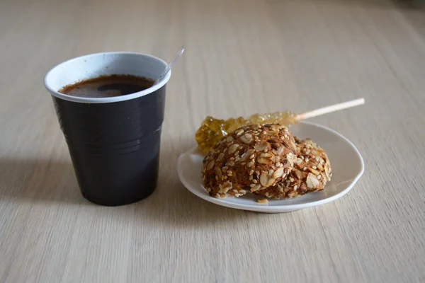 Plastic cup of coffee with biscuits and sugar — Stock Photo, Image