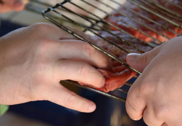 Manos de dos hombres cierre de la parrilla de la barbacoa — Foto de Stock