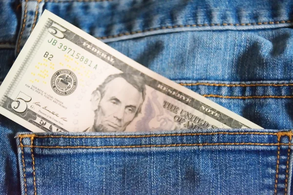 Пять долларов в кармане джинсов — стоковое фото