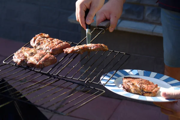Hand nemen barbecue vlees van de grill — Stockfoto