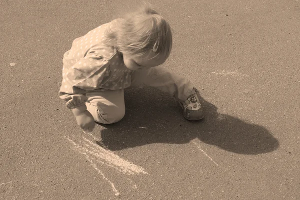 Blonde petite fille sur le trottoir avec une craie — Photo