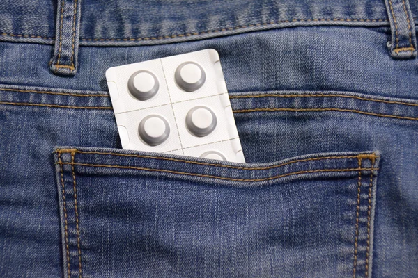 Zilveren blister met pillen in de jeans — Stockfoto