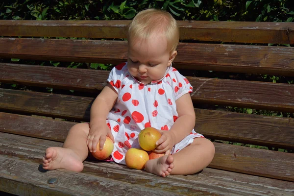A baby girl collecting apples — Stock Photo, Image