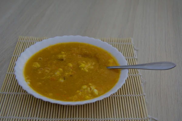 Horká polévka s kukuřicí v bílé desky na dřevěný stůl — Stock fotografie