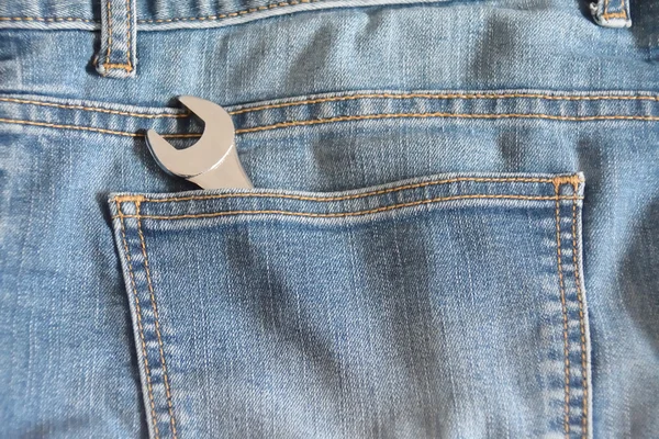 Wrench in the pocket of faded jeans — Stock Photo, Image