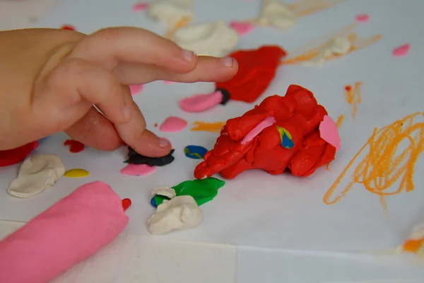 Palma del niño presionando la plastilina con el dedo —  Fotos de Stock