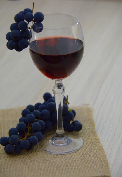 Bicchiere di vino rosso giovane con un fascio d'uva — Foto Stock