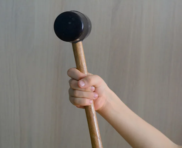 Mazo de goma en la mano del niño, en el mango de madera — Foto de Stock