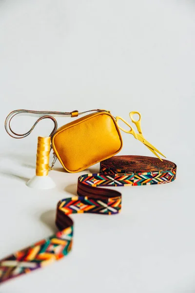 Bolsa de cuero amarillo y accesorios de costura sobre fondo blanco. Imagen De Stock