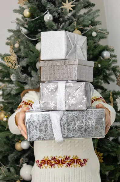 Arka planda noel ağacı olan bir sürü hediye var.