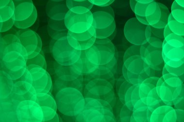 Koyu arkaplanda bulanık yeşil bokeh ışıkları