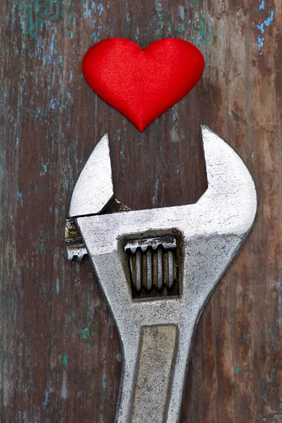 Red heart fixed by the wrench. Healing love concept