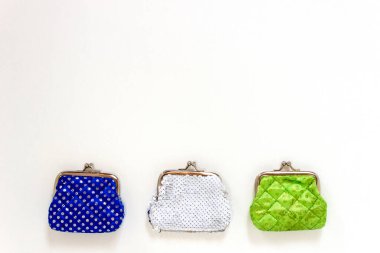 Beyaz arka planda üç cüzdan var: mavi, yeşil ve beyaz.