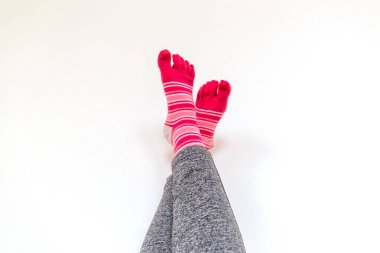 Beyaz arka planda ayrı parmakları olan pembe çoraplar.