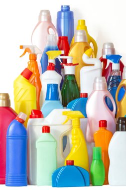 Temizlik için bir sürü kimyasalla dolu şişe. Dağ şeklinde farklı plastik şişeler. Beyaz arka planda bir sürü renkli şişe yığını