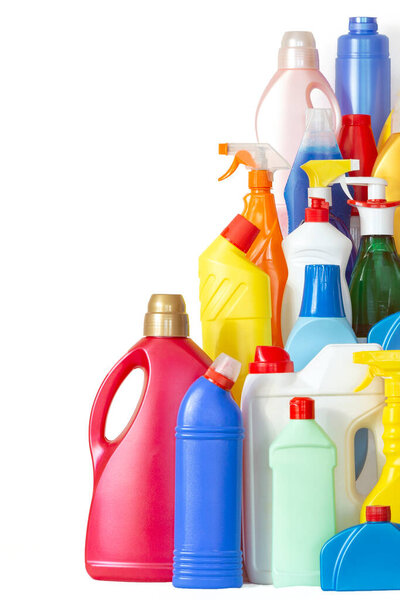 Много бутылок с химикатами для чистки. Различные пластиковые бутылки в виде гор. Куча разноцветных бутылок на белом фоне с копировальным местом для текста