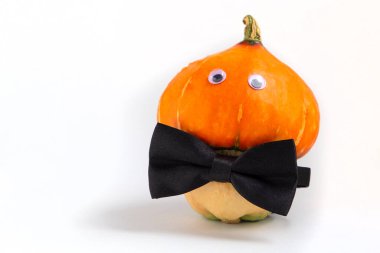 Gözleri ve mantar şeklinde papyonu olan bir balkabağı. Şükran Günü ve Cadılar Bayramı konsepti.