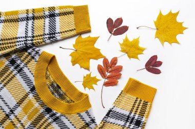 Renkli sarı ve kırmızı yapraklı, turuncu uzun kollu örgü süveter. Sonbahar renkli giysiler düz yatıyordu