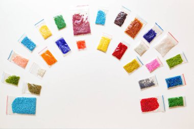 Renkli paketlenmiş boncuklar yarım daire şeklinde dizilmiş ortasındaki yazı için boşluk bırakılmış. Boncuklama el kirişleri için kopyalama alanı olan yaratıcı düz bir yer