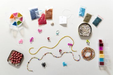 Yaratıcı, parlak ve renkli boncuklar beyaz masada. El sanatları işyeri. Güzel diy mücevher ve rahatlatıcı stres rahatlatıcı hobi ve aktivite
