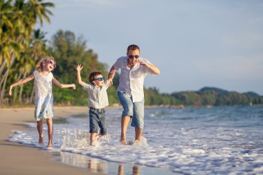 Baba ve çocuk kumsalda gün anda oynamak.