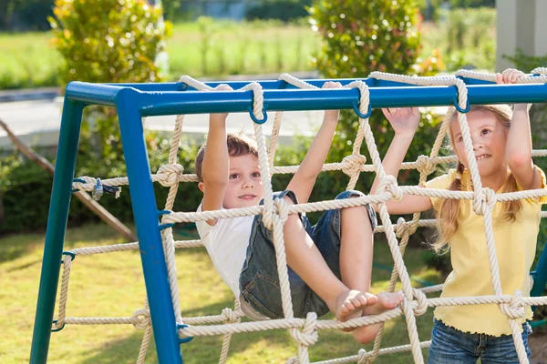 Счастливые брат и сестра, играющие на детской площадке — стоковое фото