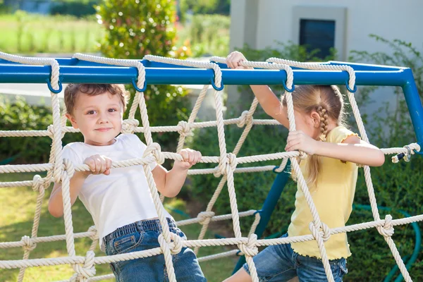 Счастливые брат и сестра, играющие на детской площадке — стоковое фото
