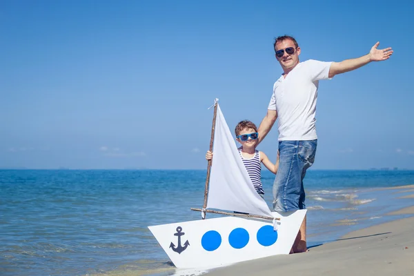 Vader en zoon spelen op het strand op het moment van de dag. — Stockfoto