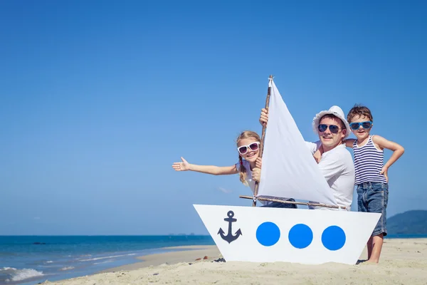 Far och barn som leker på stranden på dagarna. — Stockfoto