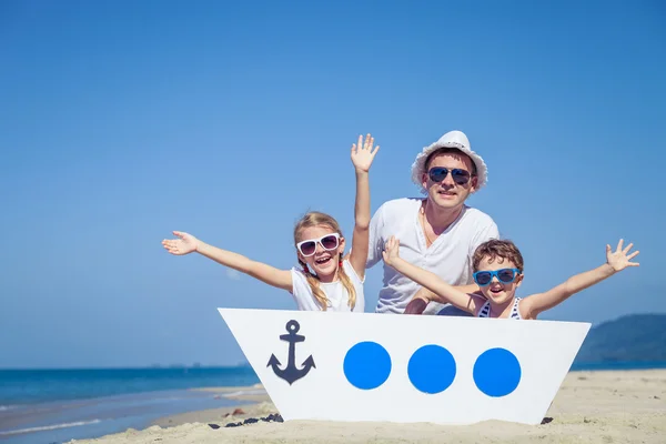 Far och barn som leker på stranden på dagarna. — Stockfoto