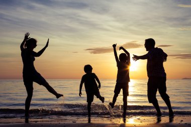 mutlu aile silüeti sunse plajda oynayan