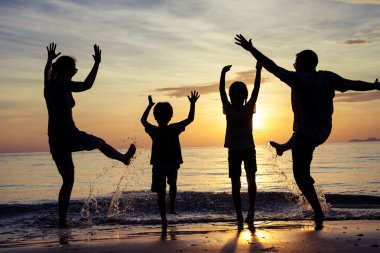 mutlu aile silüeti sunse plajda oynayan