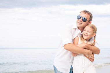 Baba ve kızı kumsalda gün anda oynamak.