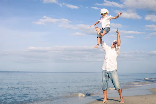 Vader en zoon spelen op het strand op het moment van de dag. — Stockfoto