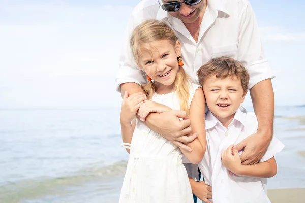 Father and children playing on the beach at the day time. — Stock Photo, Image