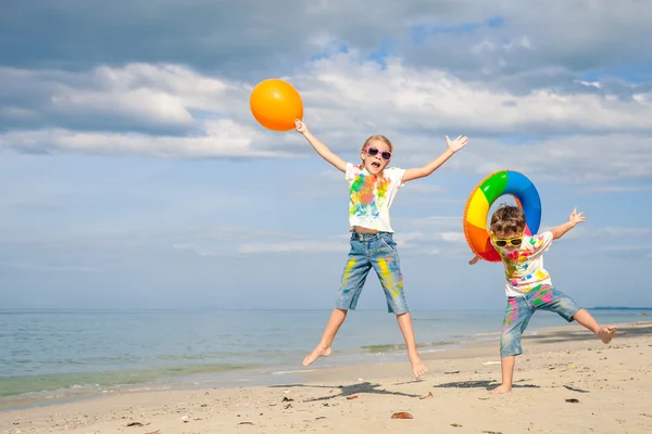 De gelukkige kinderen spelen op het strand op het moment van de dag. — Stockfoto