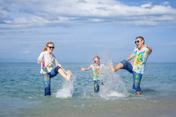 Familie fericită jucându-se pe plajă în timpul zilei . — Fotografie, imagine de stoc