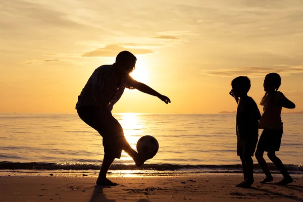 Father and children playing on the beach at the sunset time. — Stock Photo, Image