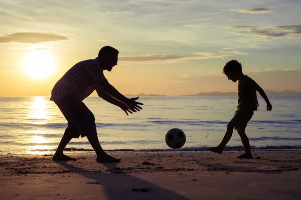 Father and son playing on the beach at the sunset time. — Stock Photo, Image