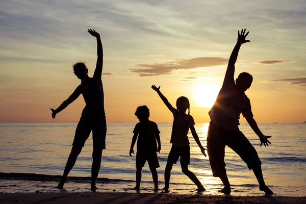Σιλουέτα της ευτυχισμένη οικογένεια που παίζει στην παραλία του sunse — Φωτογραφία Αρχείου