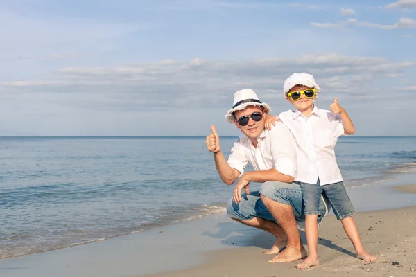 Vader en zoon spelen op het strand op het moment van de dag. — Stockfoto