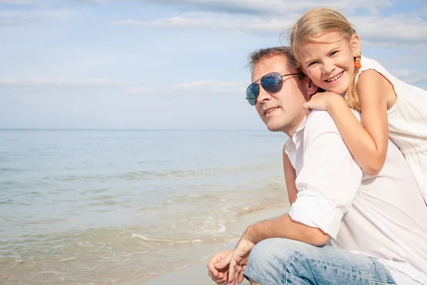 Vater und Tochter spielen tagsüber am Strand. — Stockfoto