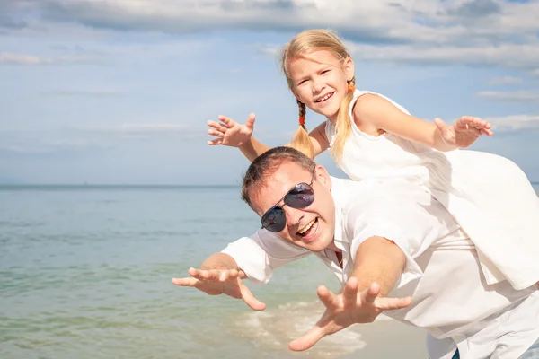 Father and daughter playing on the beach at the day time. — Stock Photo, Image