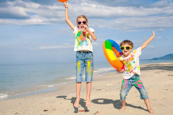 Szczęśliwe dzieci bawiące się na plaży w czasie dnia. — Zdjęcie stockowe