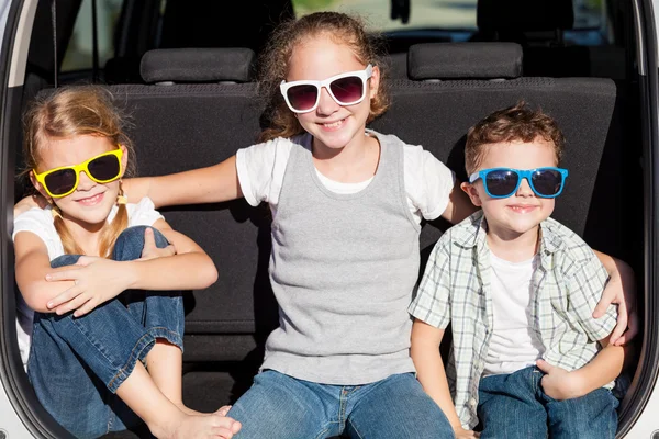 Crianças felizes se preparando para viagem de carro em um dia ensolarado . — Fotografia de Stock