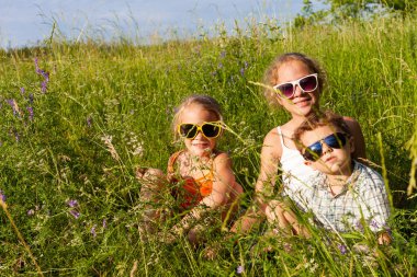 Three happy children  playing near the tree at the day time.