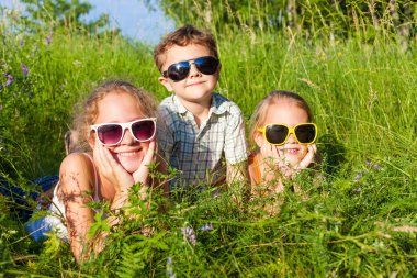 Three happy children  playing near the tree at the day time.