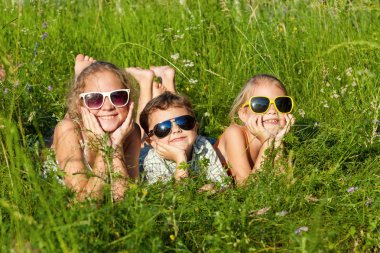 Three happy children  playing near the tree at the day time.