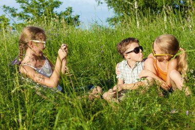 Three happy children  playing near the tree at the day time.