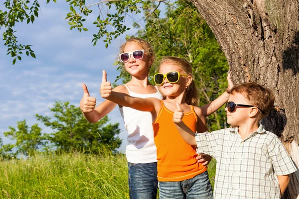 Three happy children  playing near the tree at the day time. — Zdjęcie stockowe